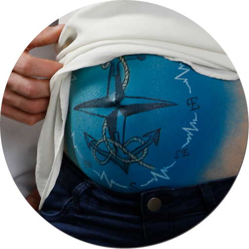 Kompass mit Anker Bodypainting: Anker, Herzkurve und Kompass auf Babybauch